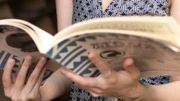 关闭 up of a comparative literature student holding an open book.