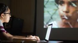 Student Megan Medrano uses her laptop while analyzing a film