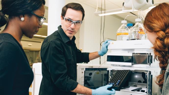 Adam Urbach works with 学生 in his chemistry lab