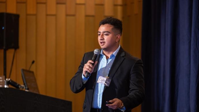 A student speaks on stage with a microphone