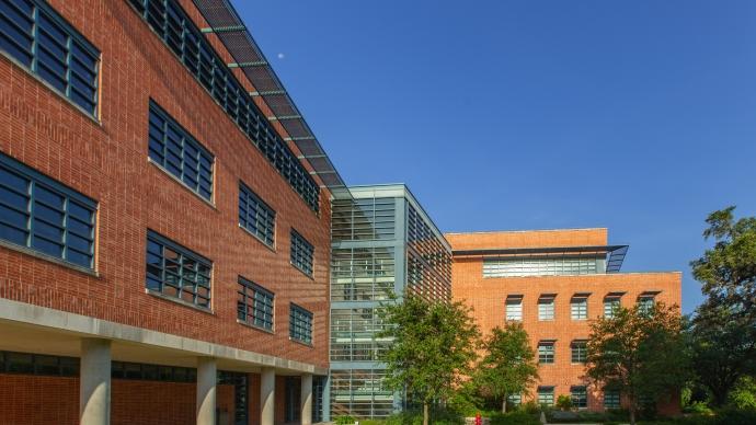 Exterior of Northrup Hall, featuring red brick, large glass windows, and trees