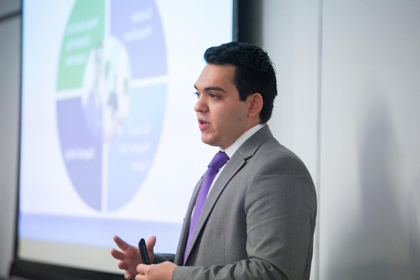 Graduate student presents a business plan in a classroom.