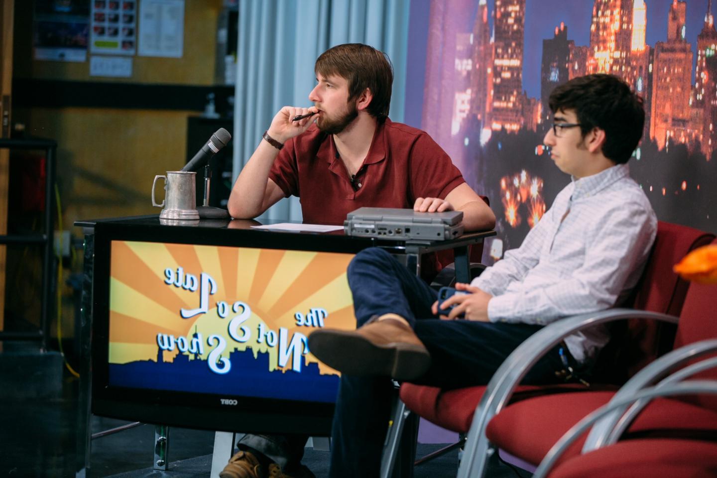 Two students are filming the Not So Late Show on the TigerTV set.